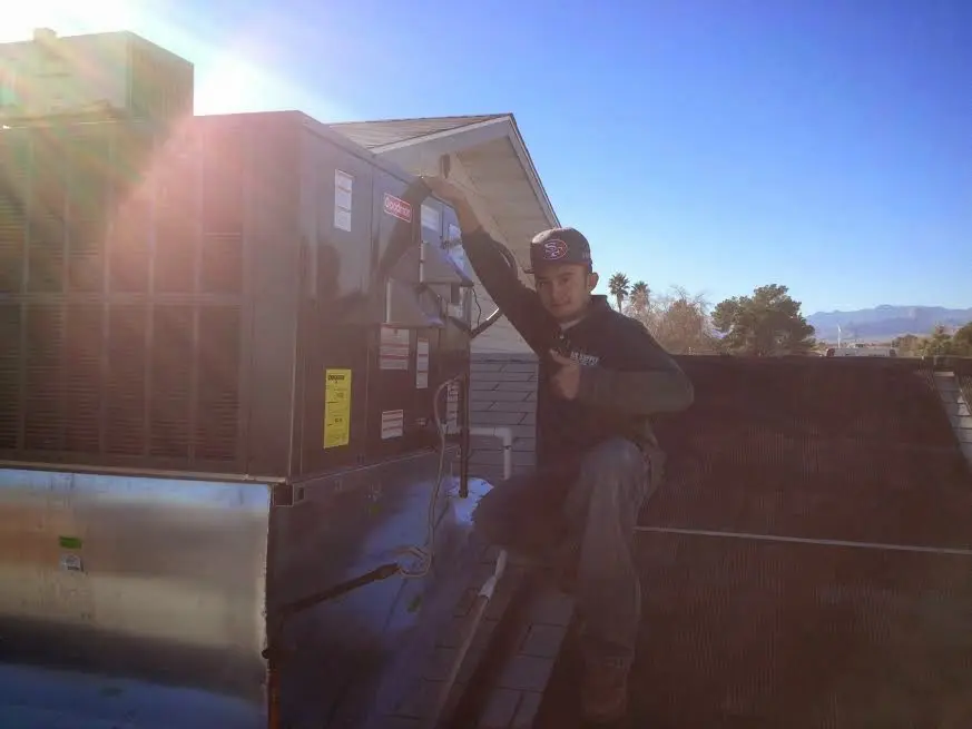 HVAC technician performing HVAC Inspection on a rooftop unit in The Crossings